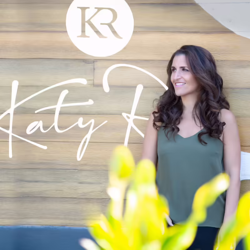 Katy Rey next to her logo