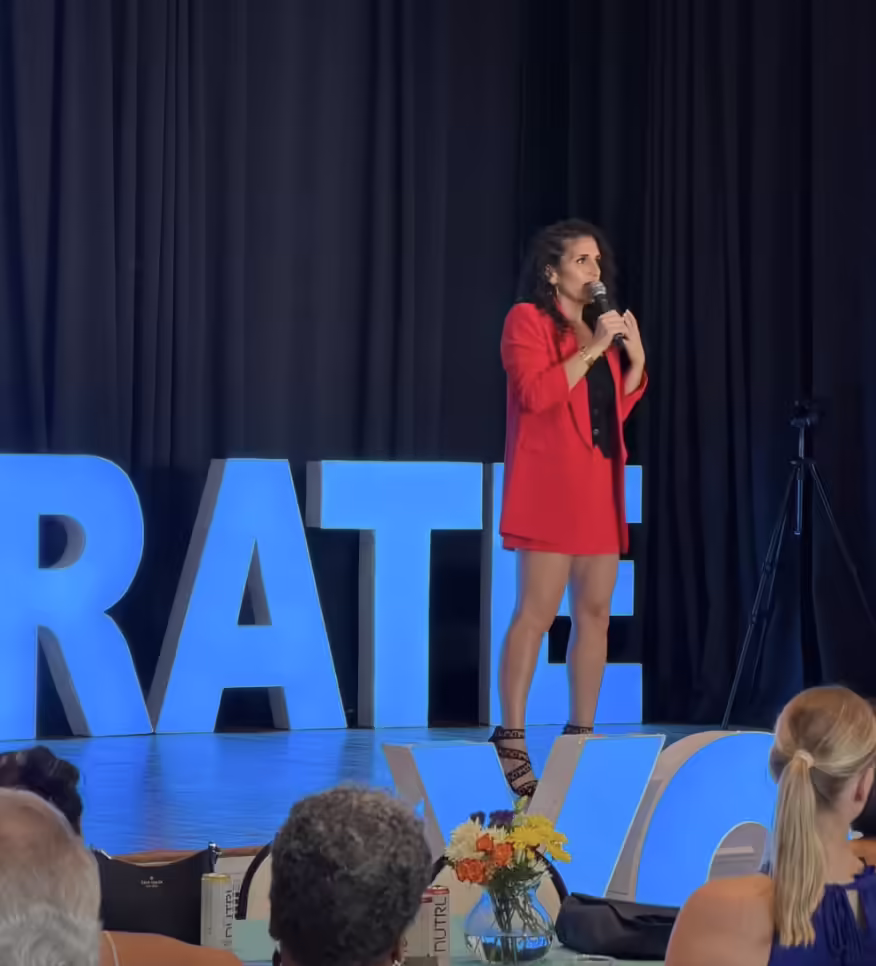 Katy Rey speaking on stage at CelebrateYOU