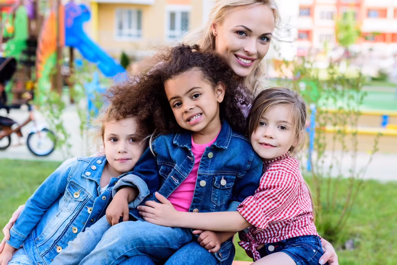 A smiling adult with children outside